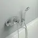 Chromene Badarmatur von Ideal Standard mit Handbrause, montiert an einer hellen Wand, mit einem schlanken und funktionalen Design.